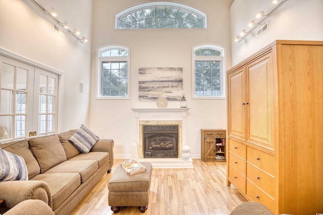 living room with a towering ceiling and light hardwood / wood-style flooring