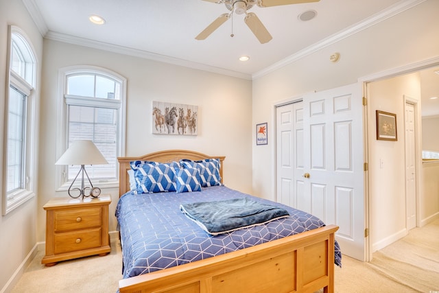 bedroom with light colored carpet, a closet, ornamental molding, and ceiling fan