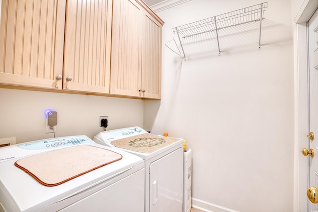 clothes washing area with cabinets, independent washer and dryer, and ornamental molding