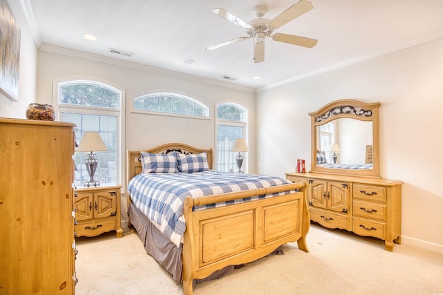 carpeted bedroom with ceiling fan and ornamental molding