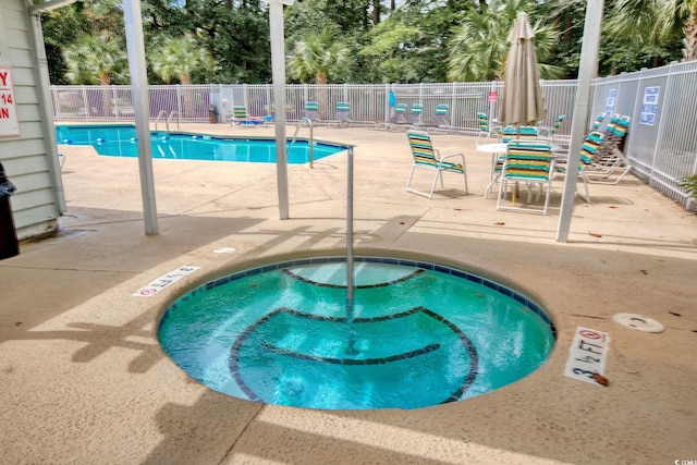 view of pool with a patio area and a hot tub