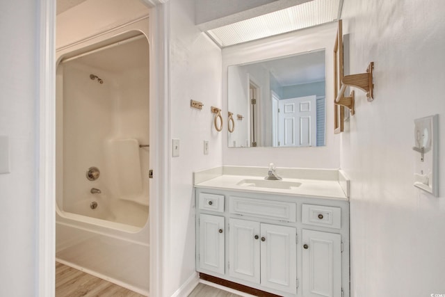 bathroom with shower / washtub combination, wood-type flooring, and vanity