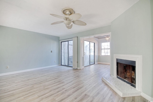 unfurnished living room with a textured ceiling, ceiling fan, and light hardwood / wood-style flooring