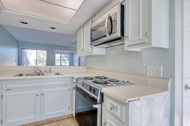 kitchen with sink, white cabinetry, electric stove, and kitchen peninsula