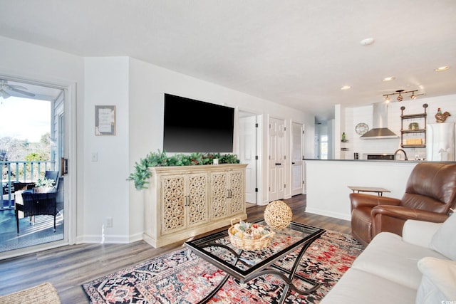 living room featuring ceiling fan, sink, and dark hardwood / wood-style flooring