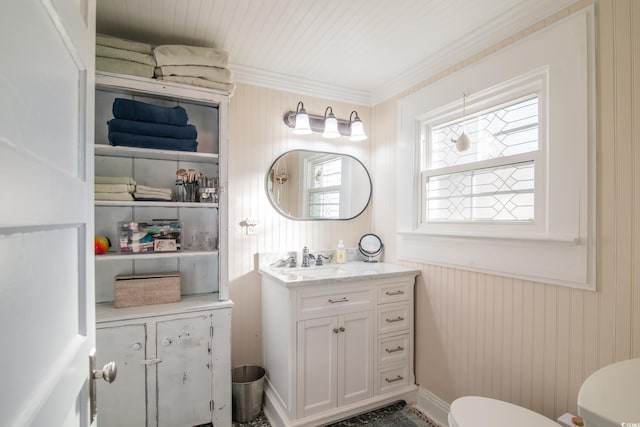 bathroom with toilet, crown molding, and vanity