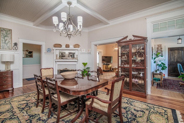 dining room with hardwood / wood-style flooring, crown molding, beam ceiling, and a chandelier