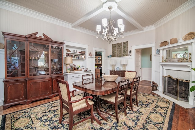 dining room featuring beam ceiling, built in features, light hardwood / wood-style flooring, and a tile fireplace