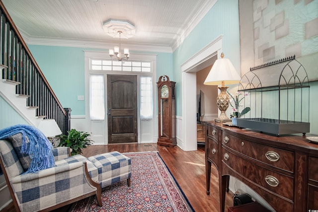 entryway with wood-type flooring, a notable chandelier, and ornamental molding