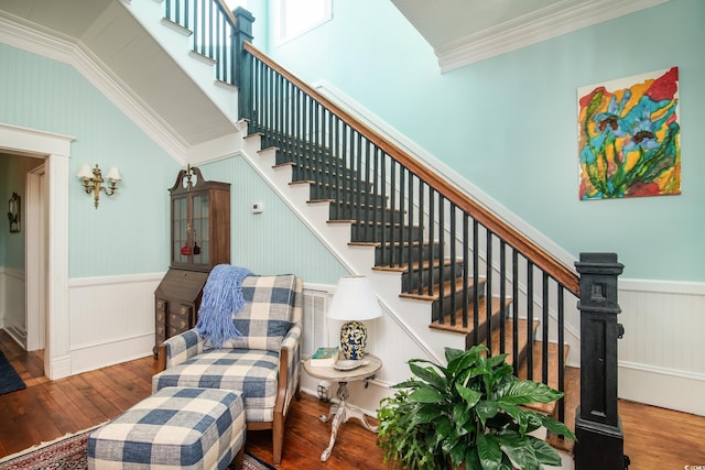 staircase with vaulted ceiling, crown molding, and wood-type flooring