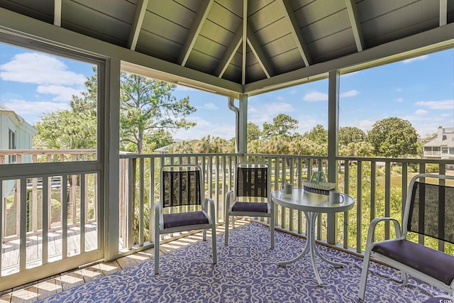 unfurnished sunroom with vaulted ceiling with beams and a healthy amount of sunlight