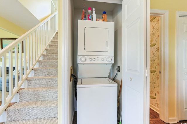 clothes washing area with hardwood / wood-style flooring and stacked washing maching and dryer