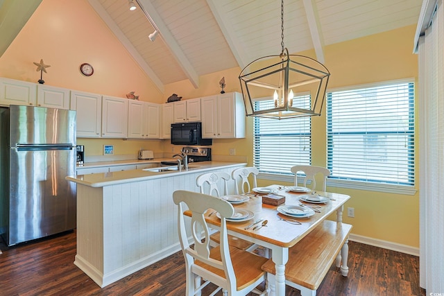 kitchen with sink, decorative light fixtures, white cabinetry, dark hardwood / wood-style floors, and stainless steel refrigerator