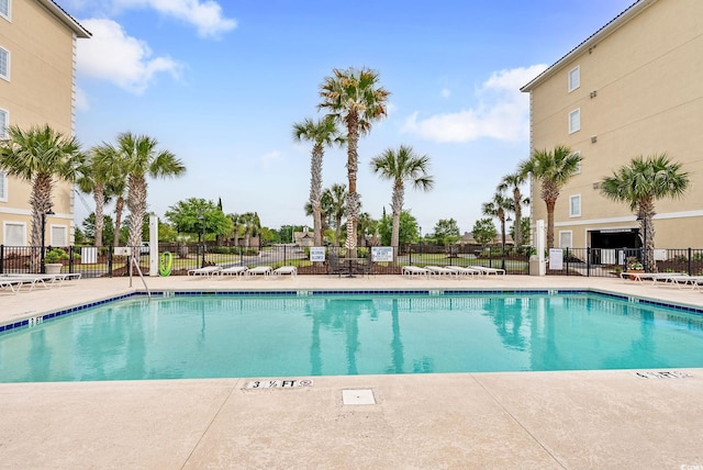 view of swimming pool featuring a patio and fence