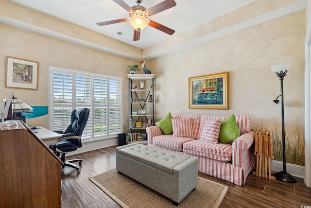 office space with ceiling fan, visible vents, baseboards, and wood finished floors