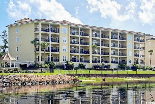 view of building exterior featuring a water view and fence