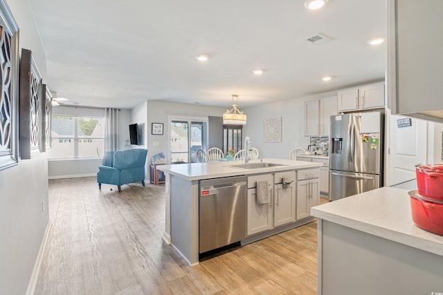 124 Golden Bear Cir, Longs, SC 29568 - kitchen with sink, hanging light fixtures, light hardwood / wood-style flooring, a center island with sink, and appliances with stainless steel finishes