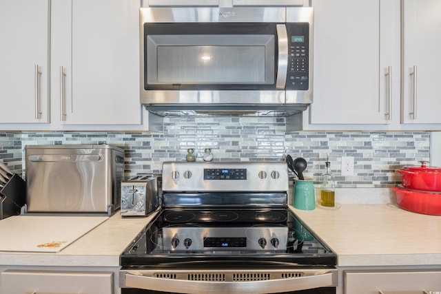 124 Golden Bear Cir, Longs, SC 29568 - kitchen featuring decorative backsplash, white cabinetry, and stainless steel appliances