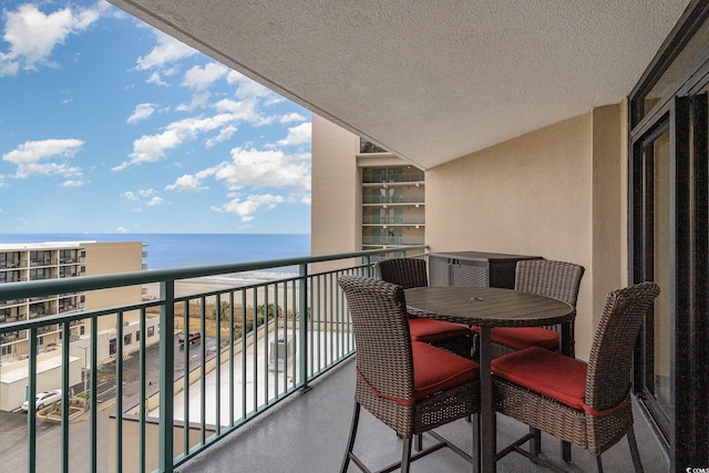 balcony featuring a beach view and a water view