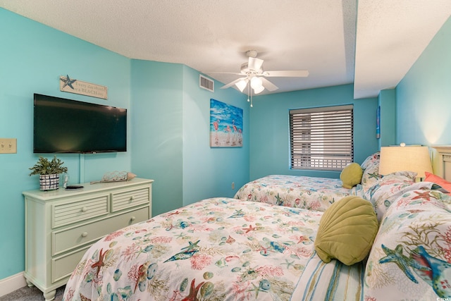 carpeted bedroom with a textured ceiling and ceiling fan