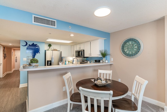 dining area featuring a textured ceiling and sink