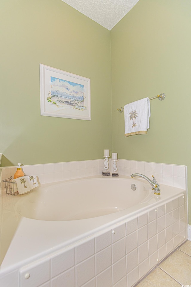 bathroom with tile patterned floors, a relaxing tiled tub, and a textured ceiling