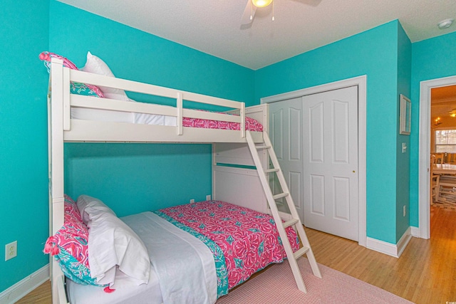 bedroom with ceiling fan, a closet, hardwood / wood-style floors, and a textured ceiling