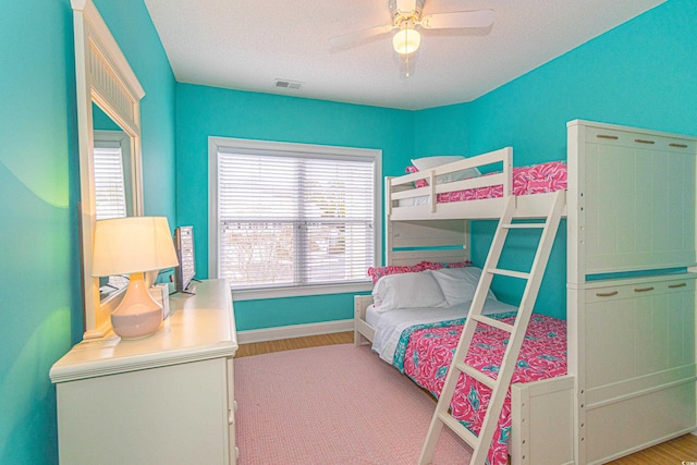 bedroom featuring ceiling fan, a textured ceiling, and light wood-type flooring