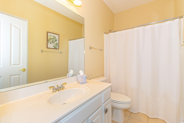 bathroom with tile patterned flooring, vanity, toilet, and a textured ceiling