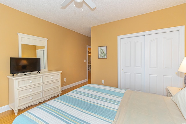 bedroom with ceiling fan, a closet, a textured ceiling, and light wood-type flooring