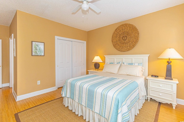 bedroom featuring a textured ceiling, ceiling fan, light hardwood / wood-style flooring, and a closet