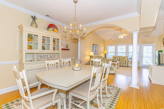 dining area with a textured ceiling, ornate columns, light hardwood / wood-style flooring, and ceiling fan with notable chandelier