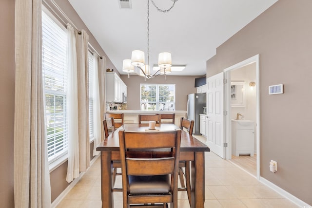 tiled dining room featuring a notable chandelier