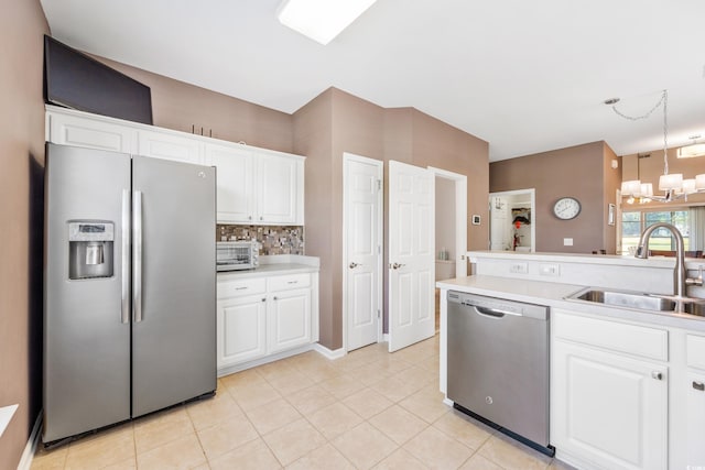 kitchen with sink, white cabinets, pendant lighting, and appliances with stainless steel finishes