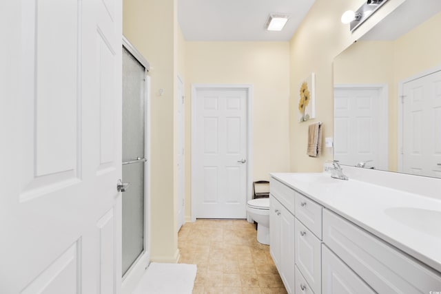 bathroom with tile patterned floors, vanity, toilet, and walk in shower