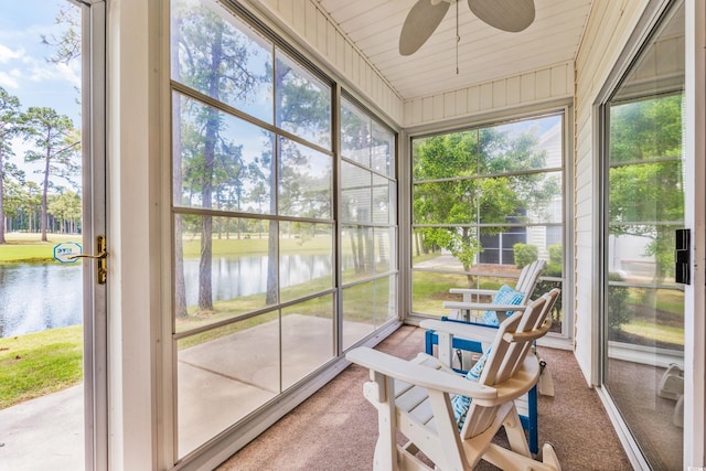 sunroom / solarium featuring ceiling fan, a water view, and a healthy amount of sunlight