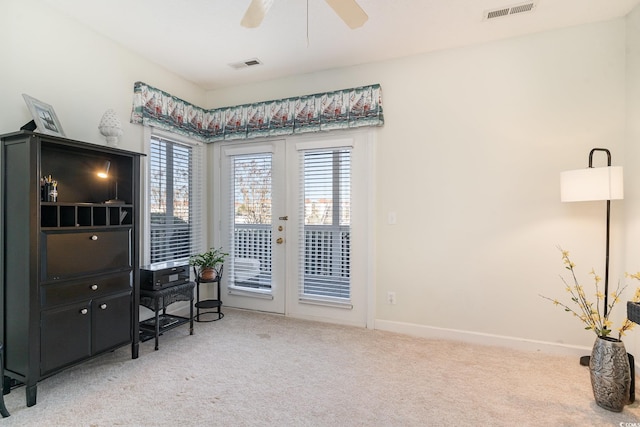 carpeted office space with french doors and ceiling fan