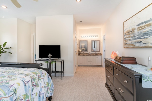 bedroom featuring connected bathroom, light colored carpet, and ceiling fan