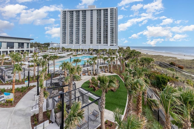 birds eye view of property with a water view and a beach view