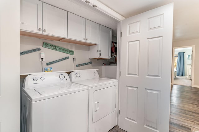 laundry area featuring cabinets, hardwood / wood-style flooring, and washing machine and clothes dryer