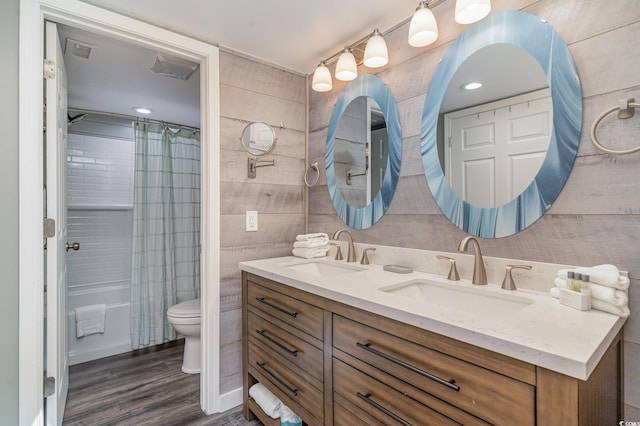 full bathroom with hardwood / wood-style floors, vanity, toilet, and shower / tub combo with curtain