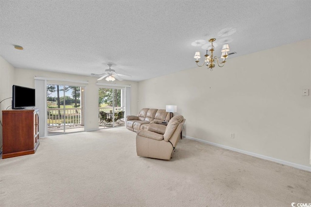 living area with carpet floors, a textured ceiling, baseboards, and ceiling fan with notable chandelier