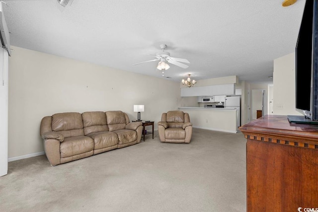 carpeted living area with baseboards and ceiling fan with notable chandelier