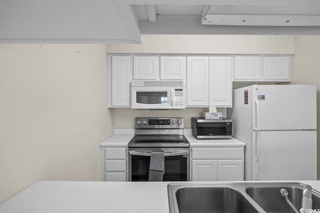 kitchen with stainless steel appliances, light countertops, a sink, and white cabinetry