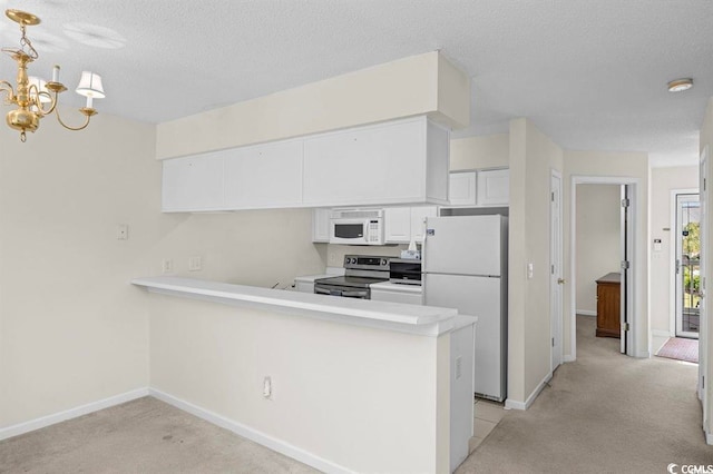 kitchen with a notable chandelier, light colored carpet, white cabinetry, white appliances, and a peninsula