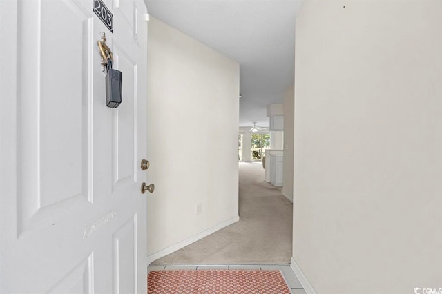 hallway with light carpet and baseboards