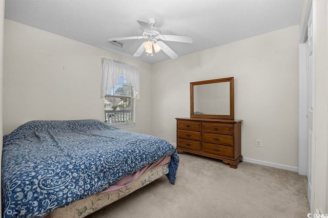 carpeted bedroom featuring a ceiling fan, visible vents, and baseboards