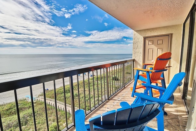 balcony with a water view and a view of the beach