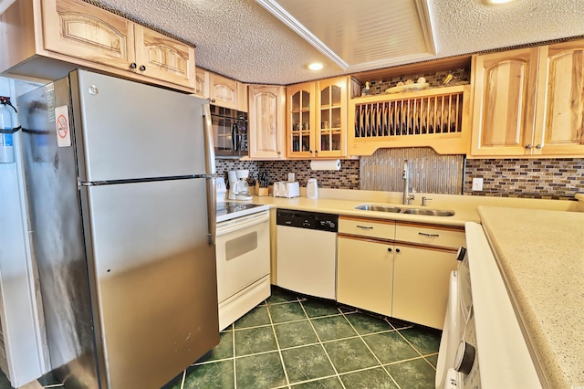 kitchen with dark tile patterned flooring, sink, white appliances, and a textured ceiling