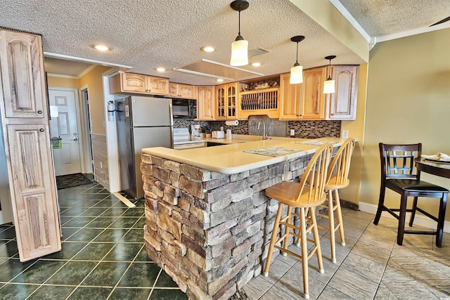 kitchen with decorative backsplash, kitchen peninsula, stainless steel refrigerator, crown molding, and a breakfast bar area